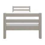 Cama individual FLEXA de la colección CLASSIC, en madera gris claro, mostrada en una habitación infantil con las barandillas visibles.