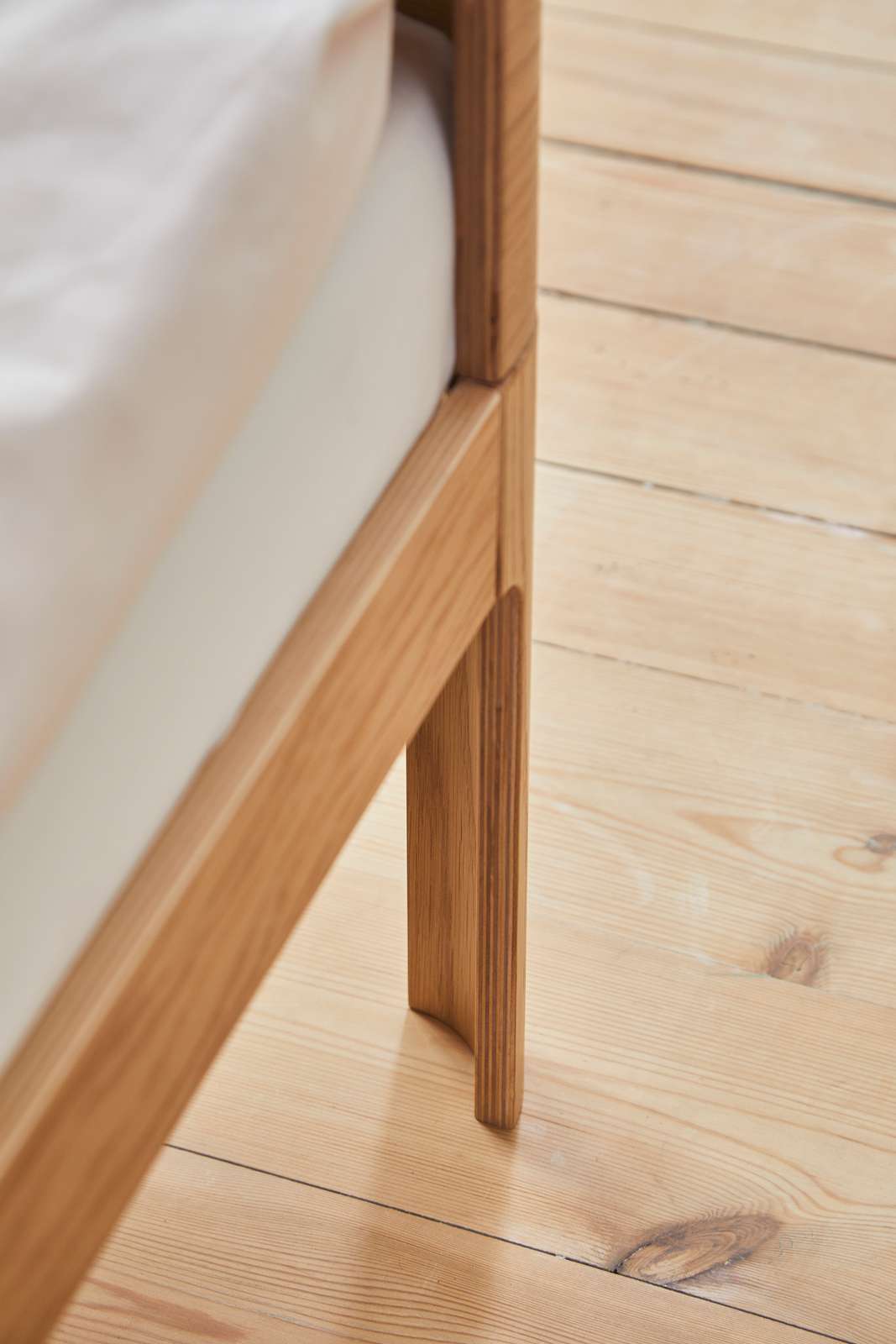 FLEXA BABY bed, oak finish, 140x70 cm with mattress on light wooden floor; rounded edges for child safety.
