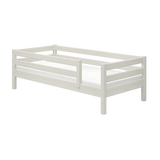 FLEXA single white bed with safety rail, Scandinavian style, wood finish, child-safe design on plain background.