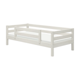 Cama individual FLEXA con barandilla de seguridad, acabado en blanco, estilo escandinavo, barandillas a prueba de niños, mostrada sobre un fondo liso.