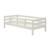 Cama individual FLEXA de la colección WHITE, de pino macizo, con acabado en blanco, barandilla de seguridad y somier de listones, en la habitación de un niño.