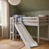 Cama alta FLEXA de la colección CLASSIC en color gris, con tobogán y barandilla de seguridad, en una habitación infantil verde.