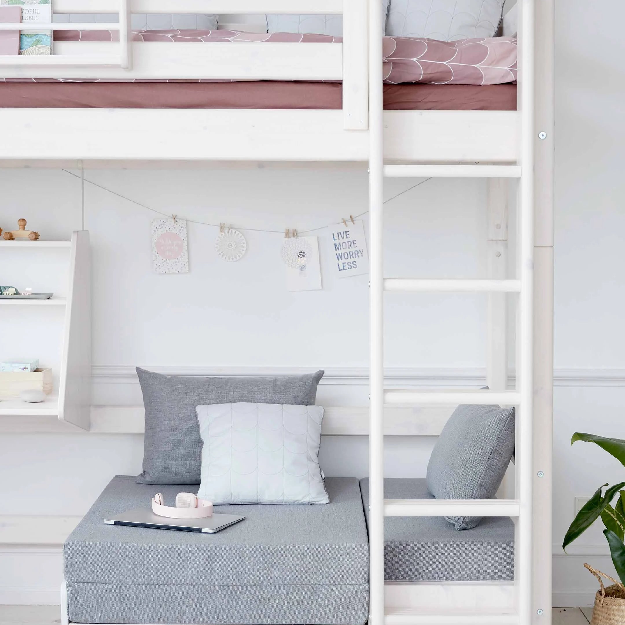CAMA ALTA FLEXA en color blanco con sofá, escritorio, escalera y barandilla de seguridad; apta para niños; se muestra en un dormitorio infantil.