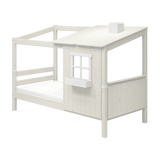 Cama individual FLEXA WHITE de la colección HOUSE, con escalera, techo inclinado, ventana y bordes seguros para los niños, en una habitación infantil.